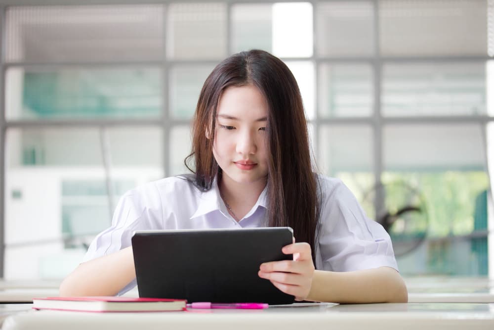 นักเรียนกำลังตั้งใจอ่านสรุปฟิสิกส์อะตอมเพื่อเตรียมตัวสอบ